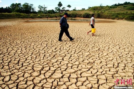 資料圖：村民從干涸的山塘走過。<a target='_blank'  data-cke-saved-href='http://www.chinanews.com/' href='http://www.chinanews.com/' _fcksavedurl='http://www.chinanews.com/' _fcksavedurl='http://www.chinanews.com/' _fcksavedurl='http://www.chinanews.com/' _fcksavedurl='http://www.chinanews.com/'></table>中新社</a>發(fā) 李愛民 攝